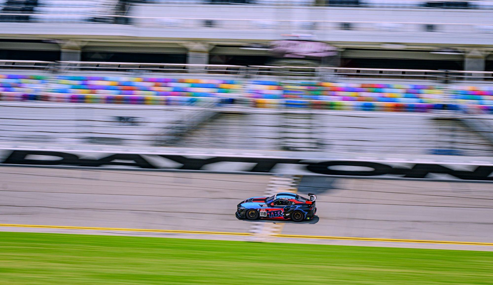 GR Cup Supra at speed past the Daytona grandstands