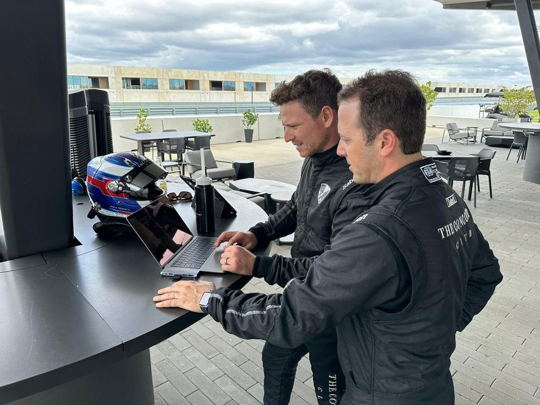 Alex Waters and a client reviewing lap video on a laptop in the paddock